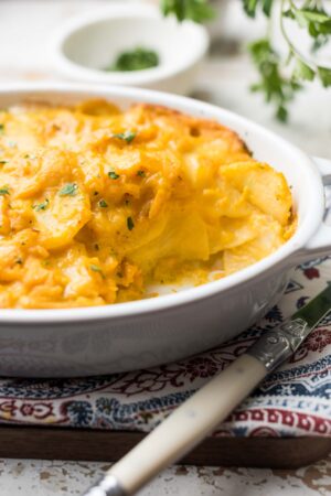 Scalloped Potatoes plant-based and dairy-free made with butternut squash in a white, oval baking dish.