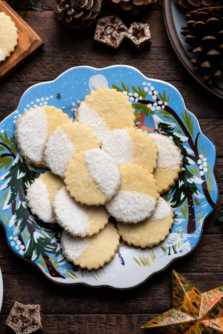 Holiday plate of Coconut Shortbread Cookies with coconut glaze and shredded coconut.