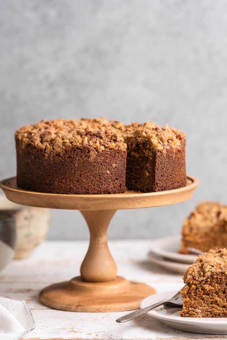 Spanish Coffee Cake on a wood cake stand with slices on the side.