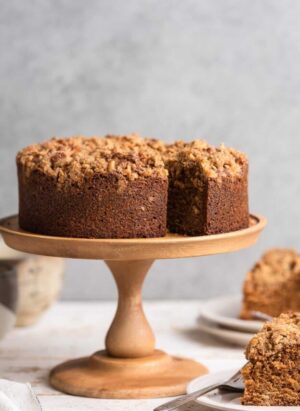 Spanish Coffee Cake on a wood cake stand with slices on the side.