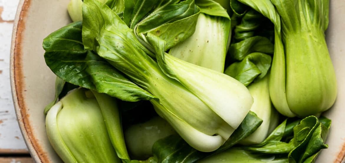 Baby bok choy in a cream bowl.