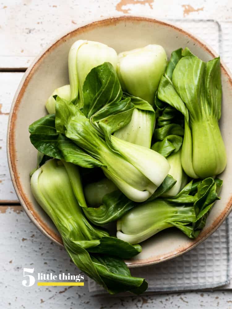 Baby bok choy in a cream bowl.