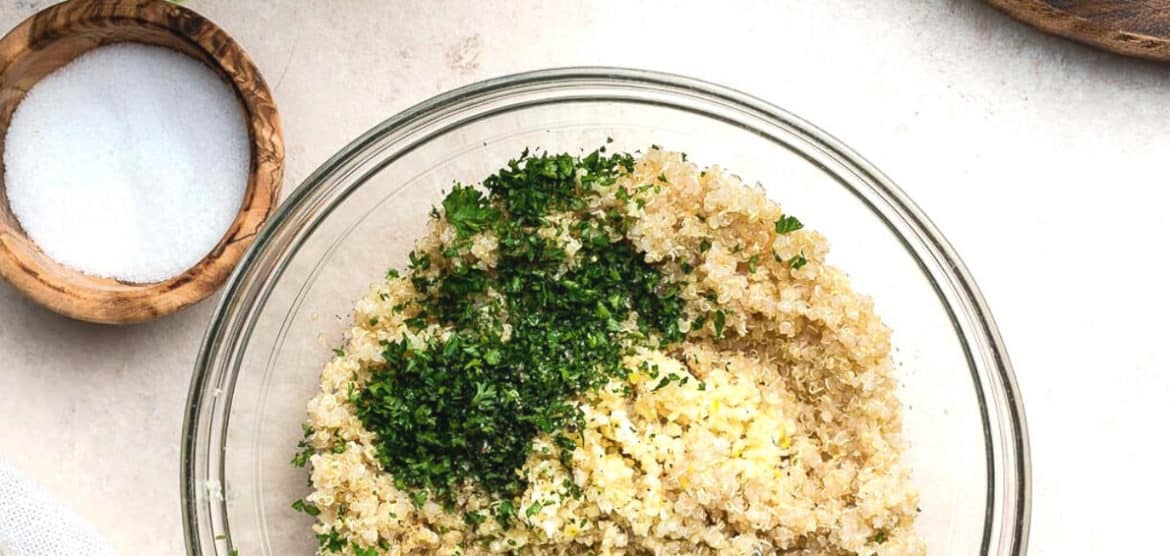 Quinoa with parsley in a clear mixing bowl.