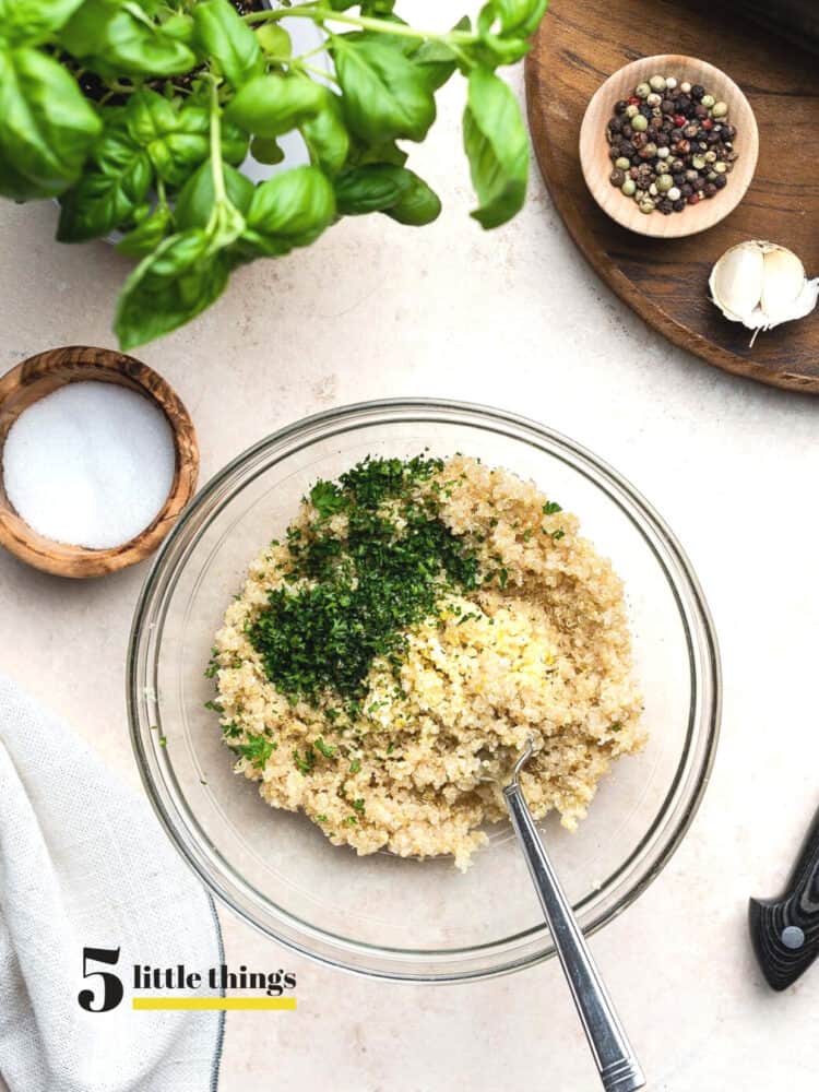 Quinoa with parsley in a clear mixing bowl.
