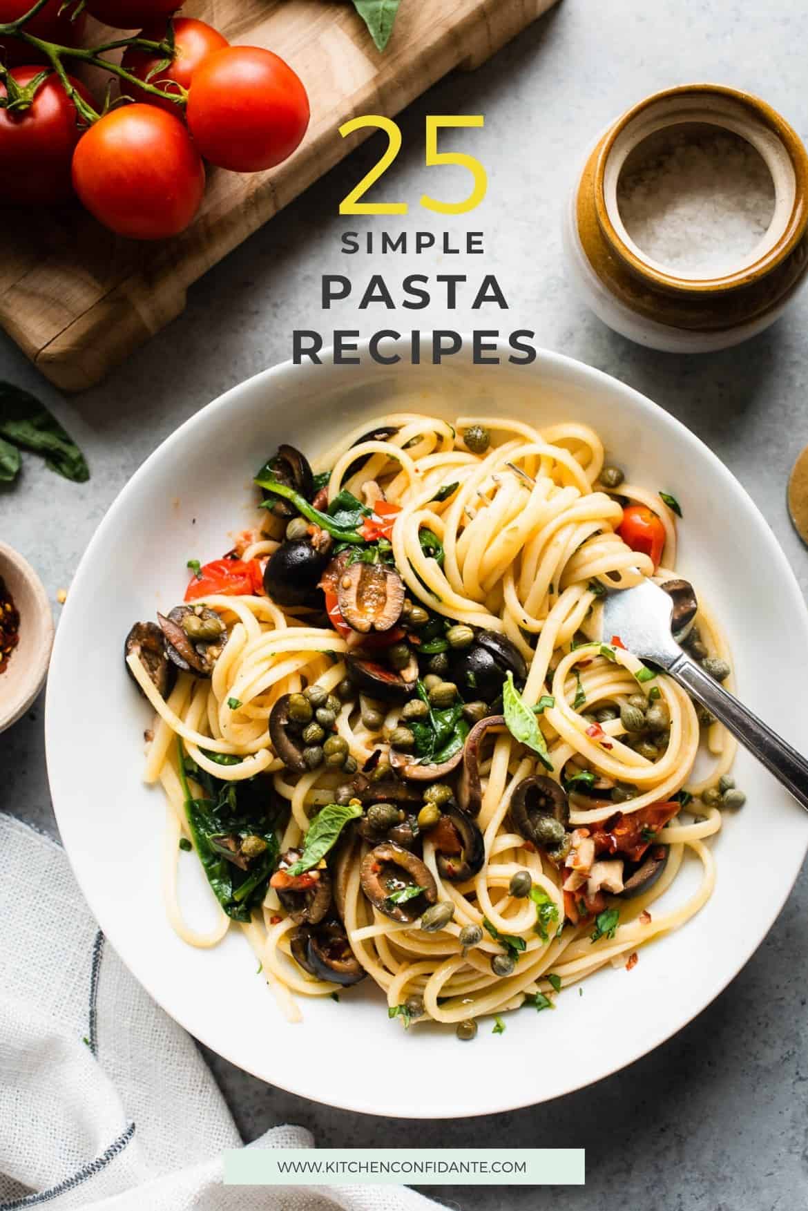 A pot with cooked fettuccine noodles and garlic, mushrooms, olive oil, and red pepper flakes around it.