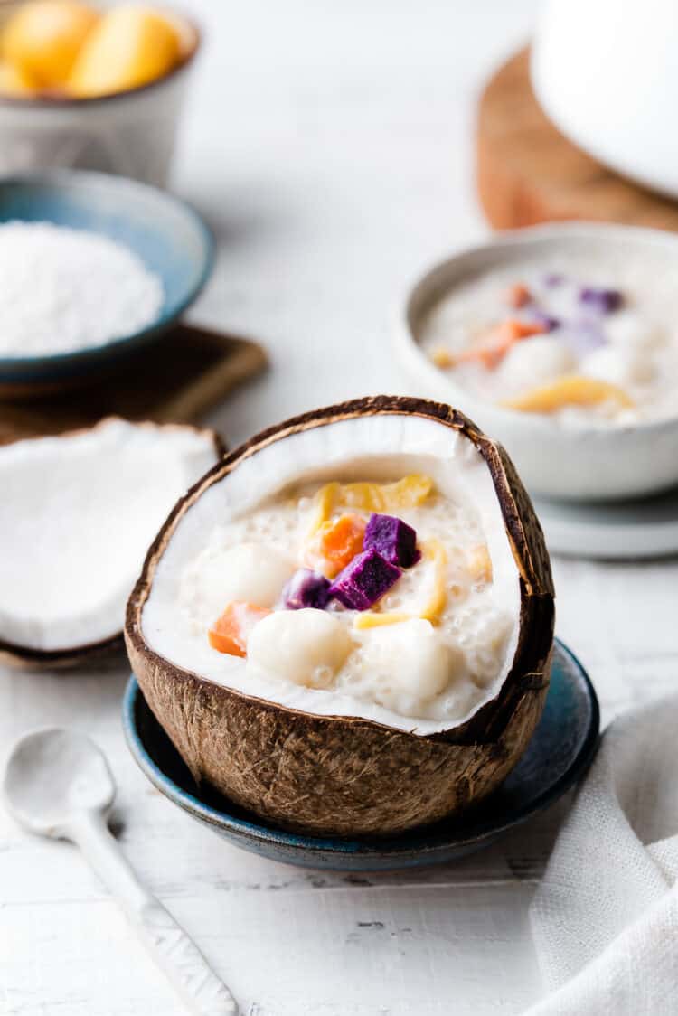 Ginataang Bilo-Bilo in a coconut shell with a white spoon nearby.