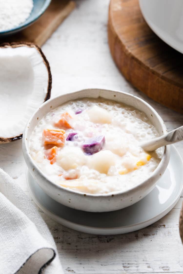 Ginataang Bilo-Bilo in a white bowl with a coconut shell nearby.