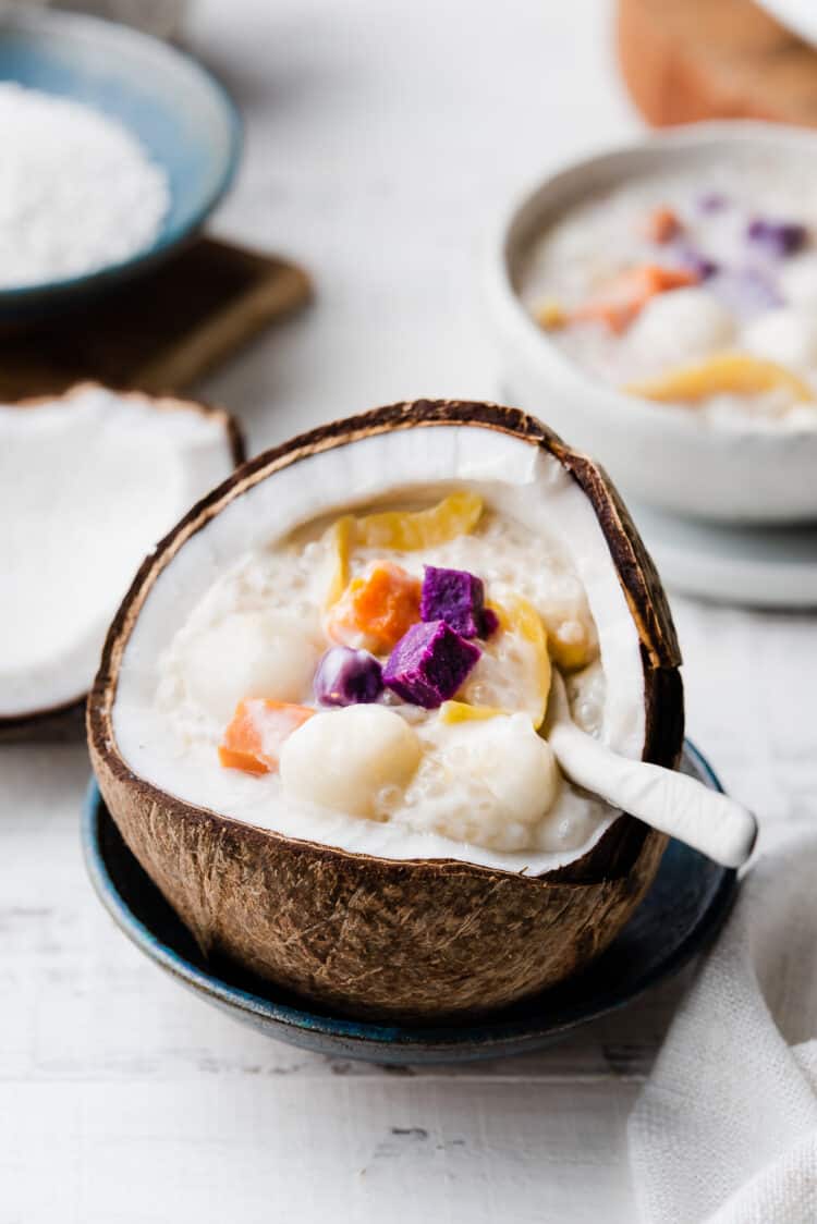 Ginataang Bilo-Bilo in a coconut shell with a white spoon.