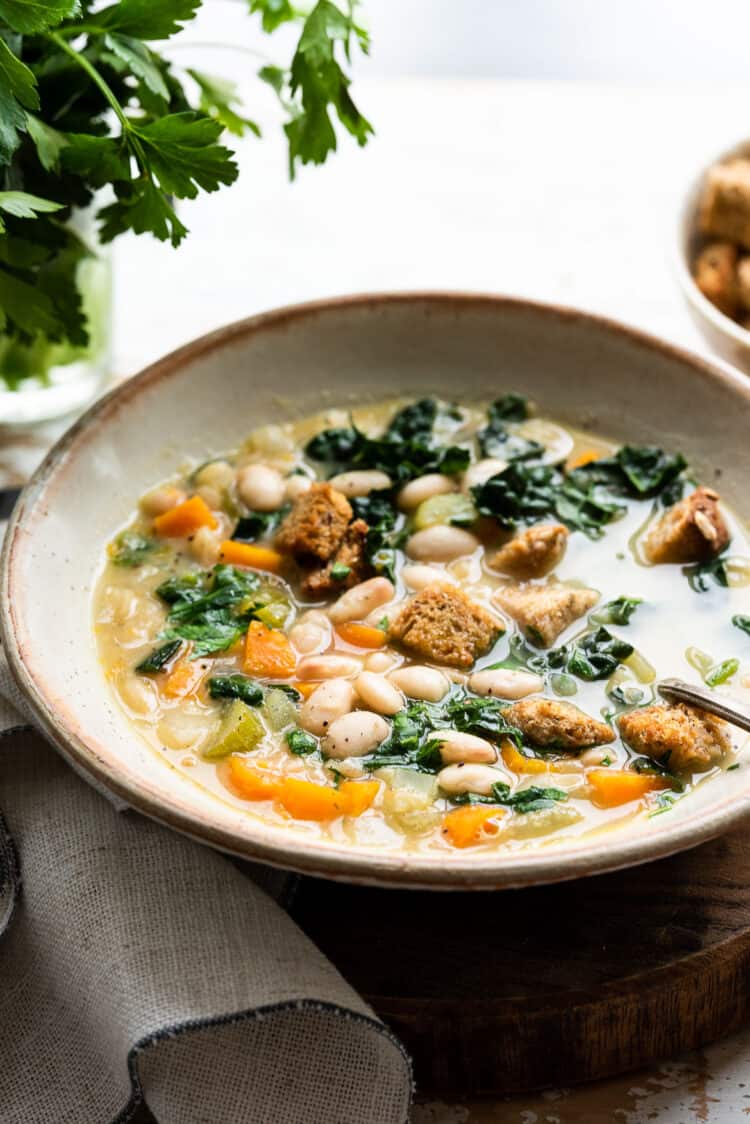 White Bean Soup with Kale in a bowl with croutons.