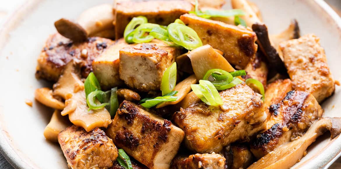 Filipino Crispy Tofu Recipe with Mushroom Adobo in a serving dish and garnished with scallions. This Fried Tofu Recipe is a delicious vegan dish!