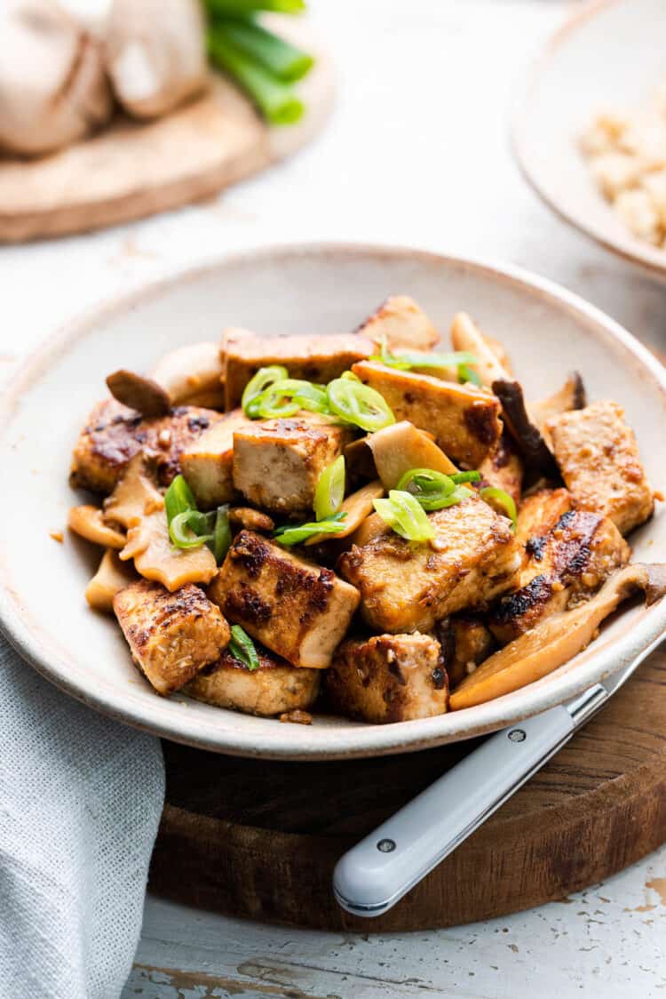 Filipino Crispy Tofu Recipe with Mushroom Adobo in a serving dish and garnished with scallions. This Fried Tofu Recipe is a delicious vegan dish!