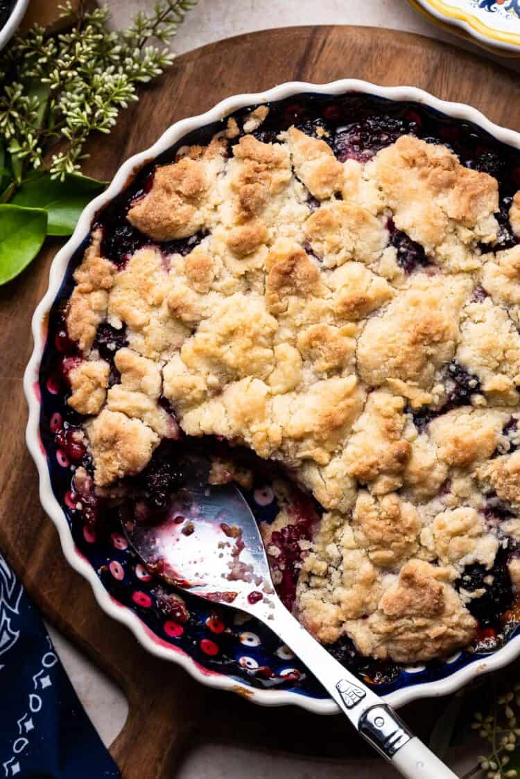 Blackberry Crumble in a ceramic pie dish on a wooden board.