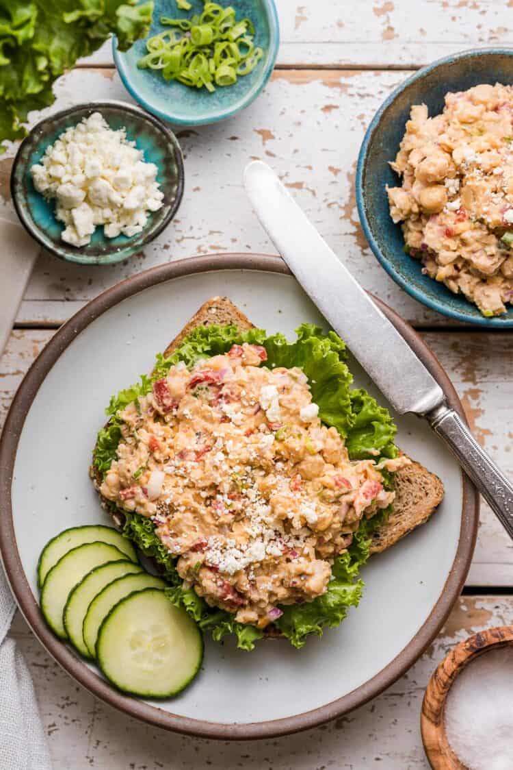 Chickpea Salad Sandwich with Feta on whole wheat bread on a plate.