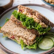 Chickpea Salad Sandwich with Feta and lettuce stacked on a plate.