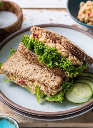 Chickpea Salad Sandwich with Feta and lettuce stacked on a plate.