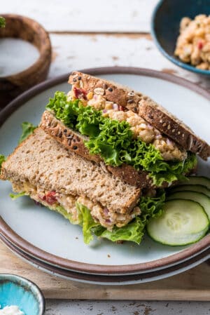 Chickpea Salad Sandwich with Feta and lettuce stacked on a plate.
