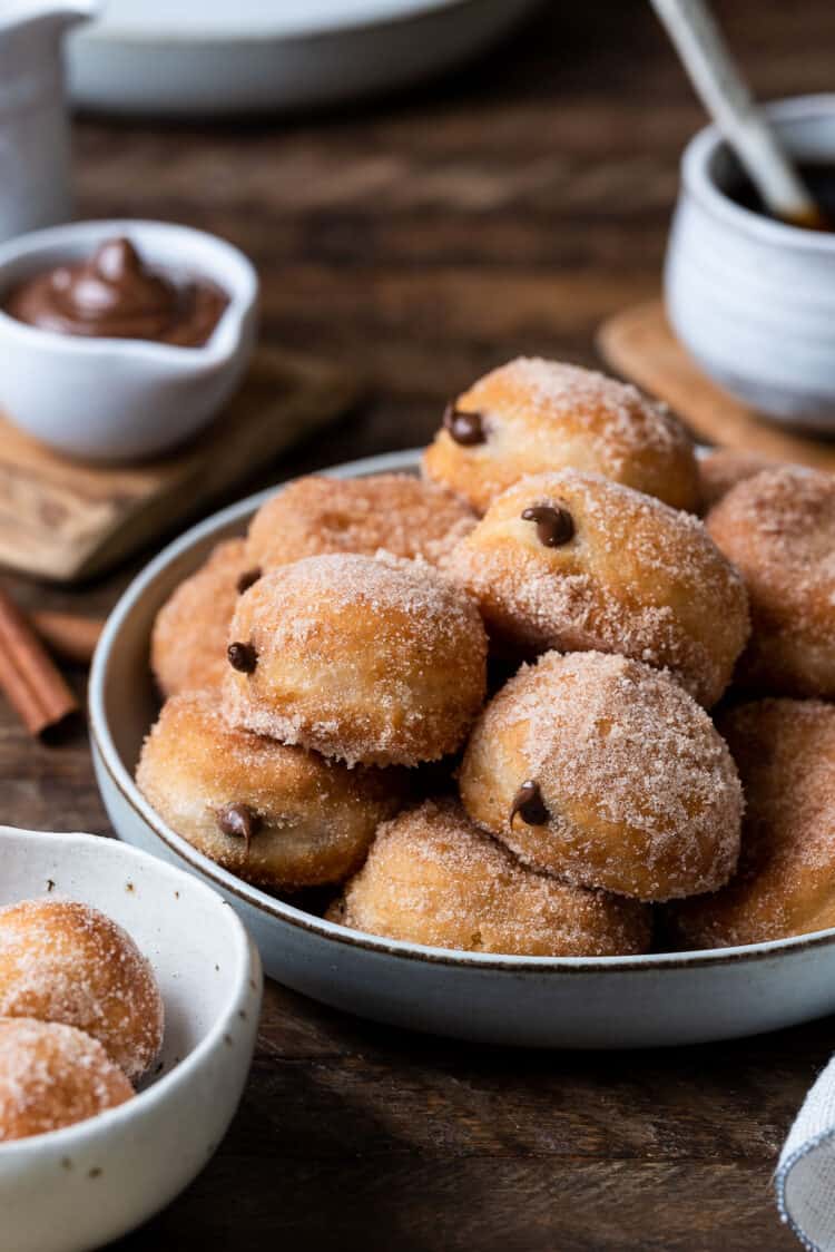 Nutella Filled Mini Doughnuts stacked on a grey plate.