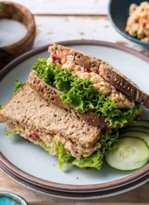Chickpea Salad Sandwich with Feta and lettuce stacked on a plate.