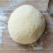 Sweet Potato Challah Bread dough on a wooden prep surface.
