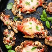 Baked Cauliflower Parmesan garnished with basil in a baking dish.