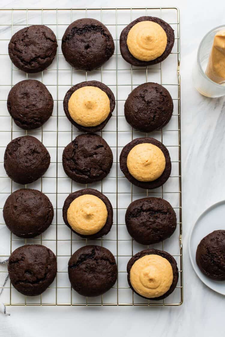 Assembling Chocolate Pumpkin Whoopie Pies on a wire rack.