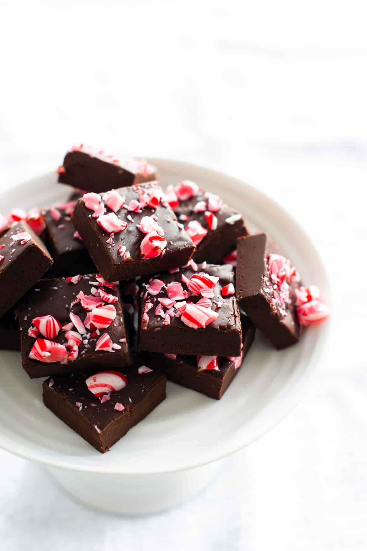 A white plate filled with squares of Dark Chocolate Kahlúa Peppermint Mocha Fudge.