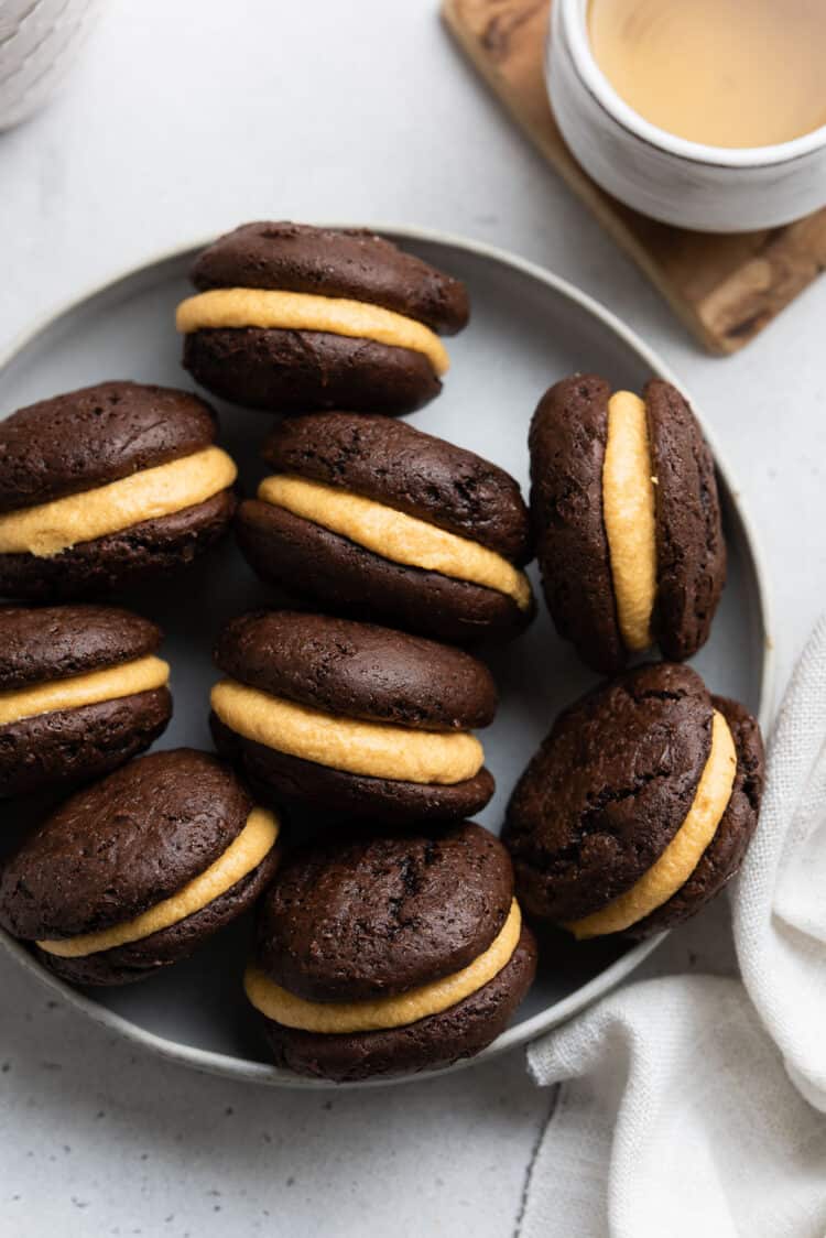 Chocolate Pumpkin Whoopie Pies in a dish on a white table.