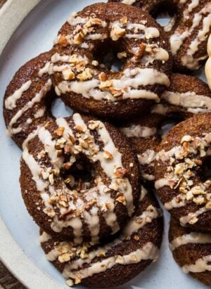A stack of Baked Pumpkin Donuts with Almond Flour and Spiced Maple Glaze on a plate.
