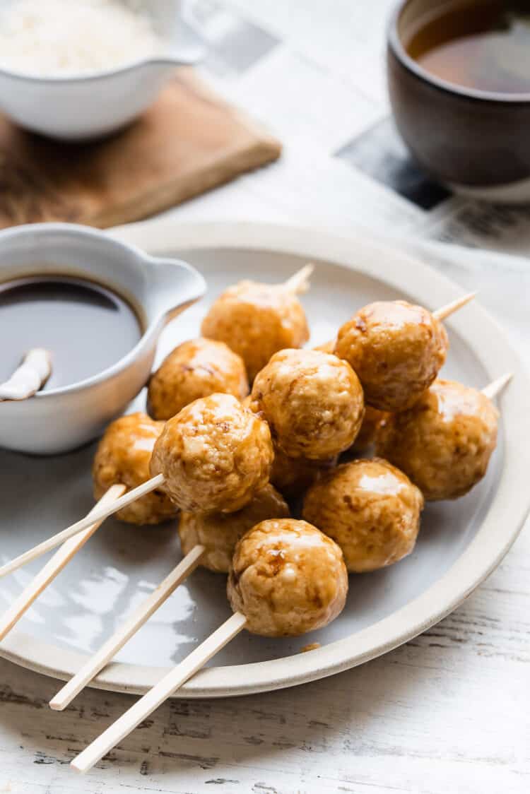 Carioca served on a stick on a plate with coconut caramel glaze on the side.