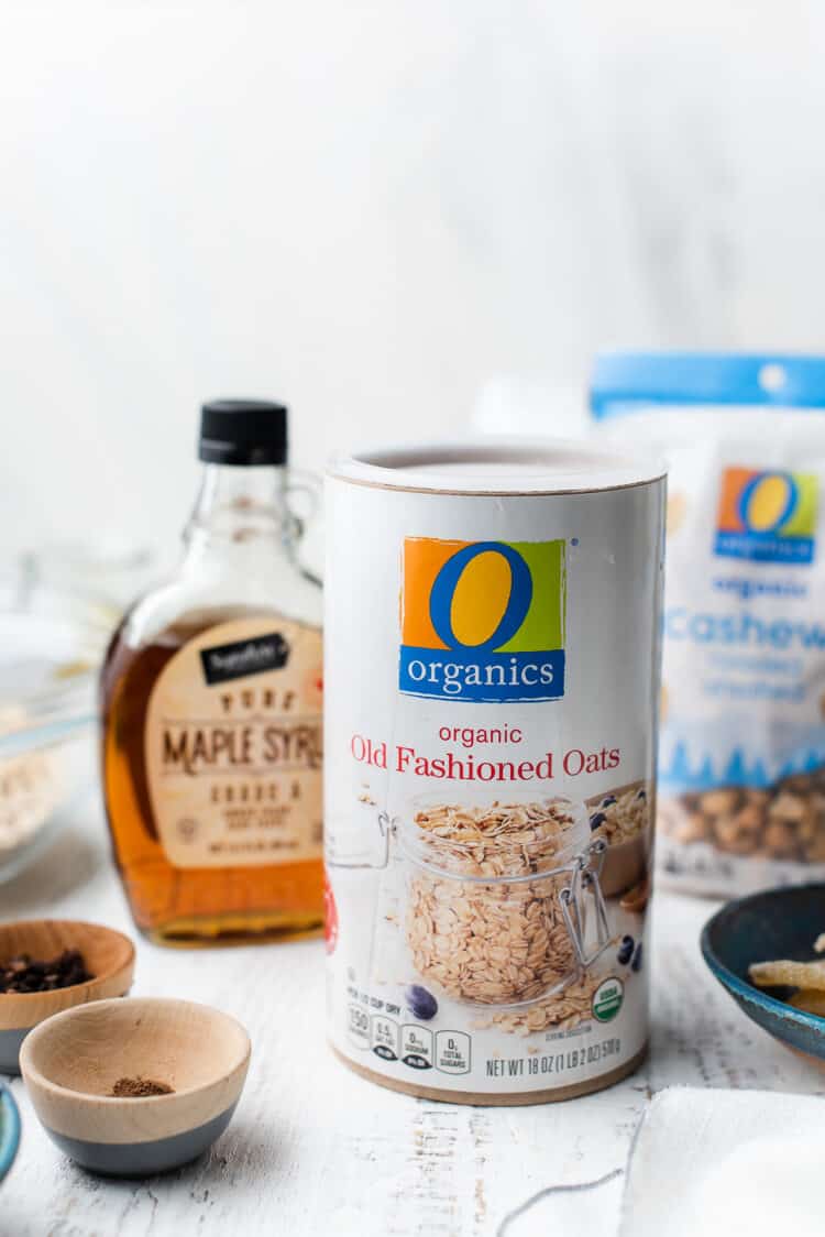 O Organics Oats with maple syrup and cashews for Gingerbread Granola on a white table.