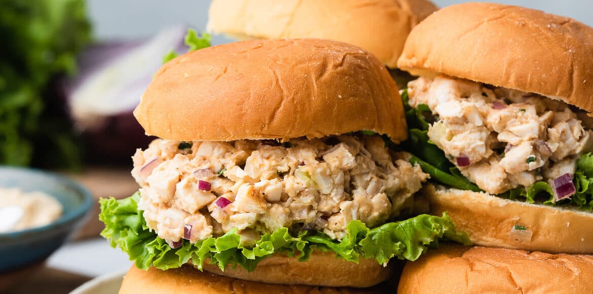 Stack of hummus chicken salad sliders in a grey dish.