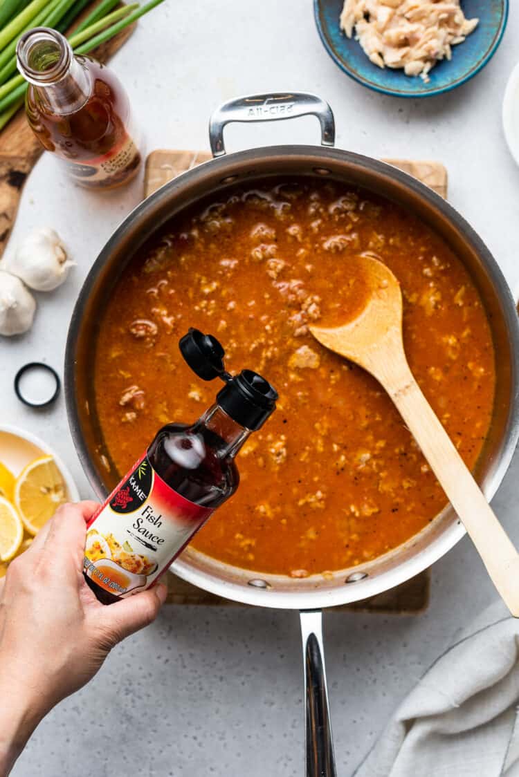 Adding fish sauce to pancit palabok sauce recipe.