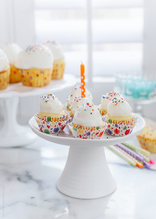 An elevated white cake stand with Ice Cream Birthday Cupcakes displayed.