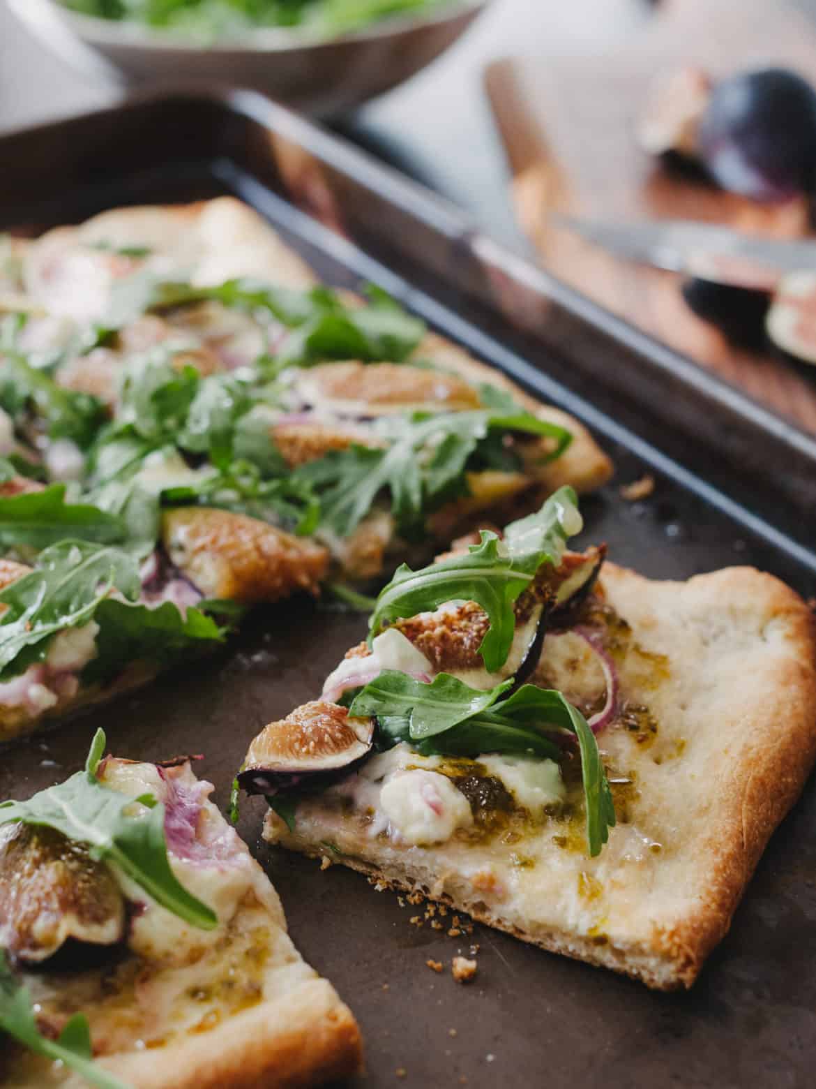 A homemade pizza topped with figs, arugula, blue cheese and jalapeno jam.