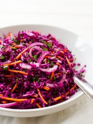 Shredded cabbage slaw in a white bowl.