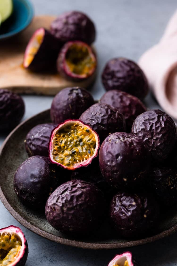 A bowl of passion fruits, with one opened.