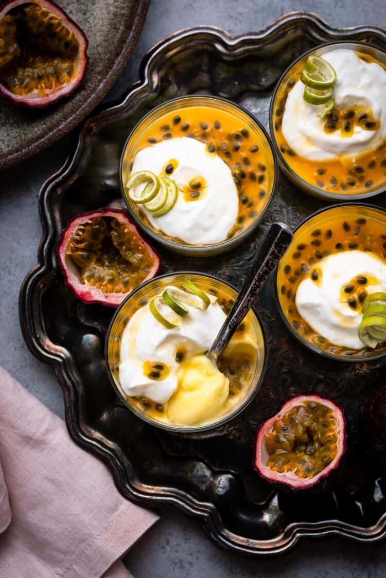 Passion Fruit Possets on a serving tray with fresh passion fruit topping.