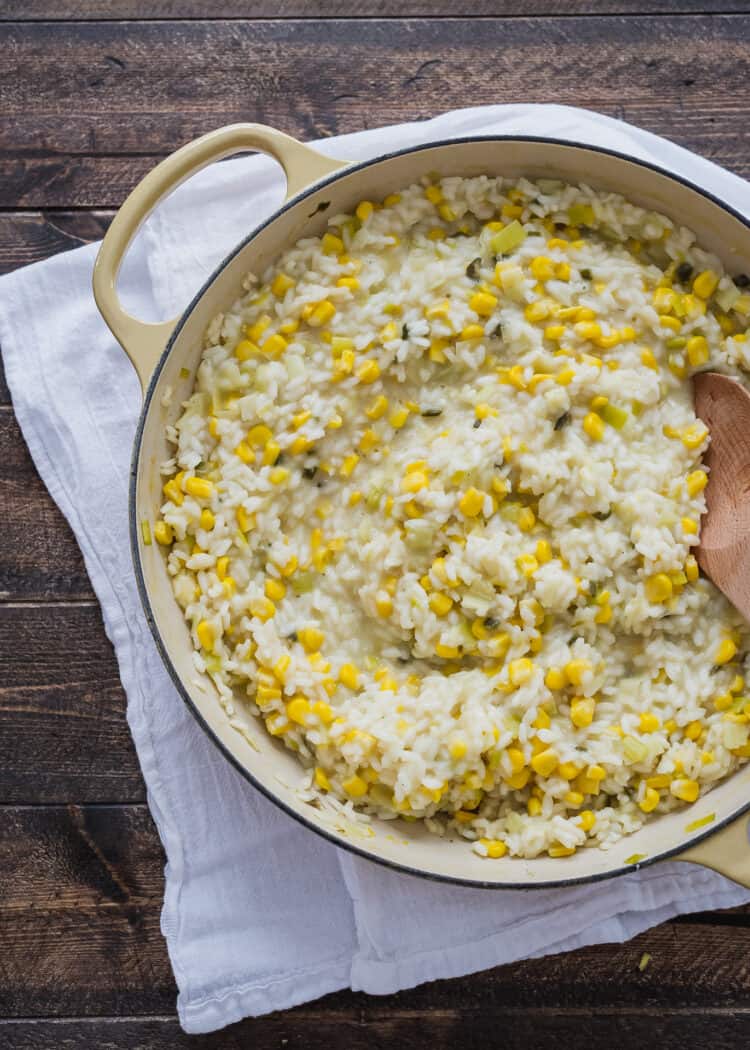 A saucepan full of freshly made risotto made of rice, corn, and leeks.