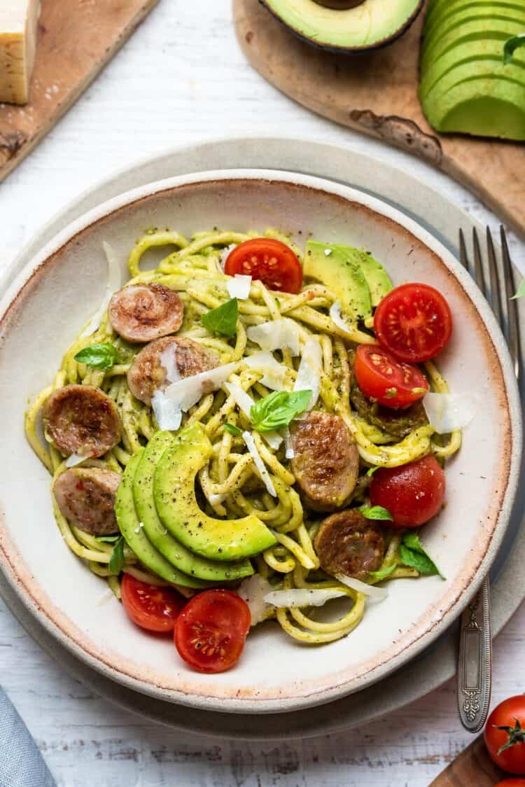 Avocado Pesto Pasta with Chicken Sausage with tomatoes, basil, and parmesan cheese.