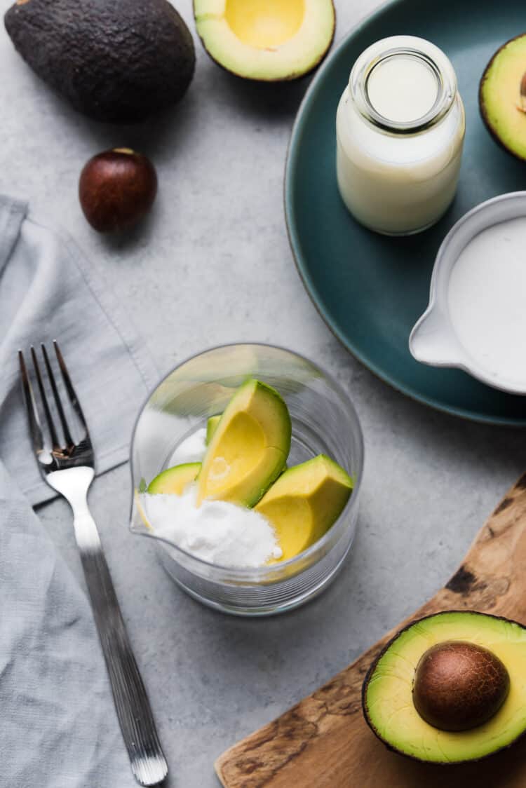 Ingredients for avocado milk smoothie in a glass jar.