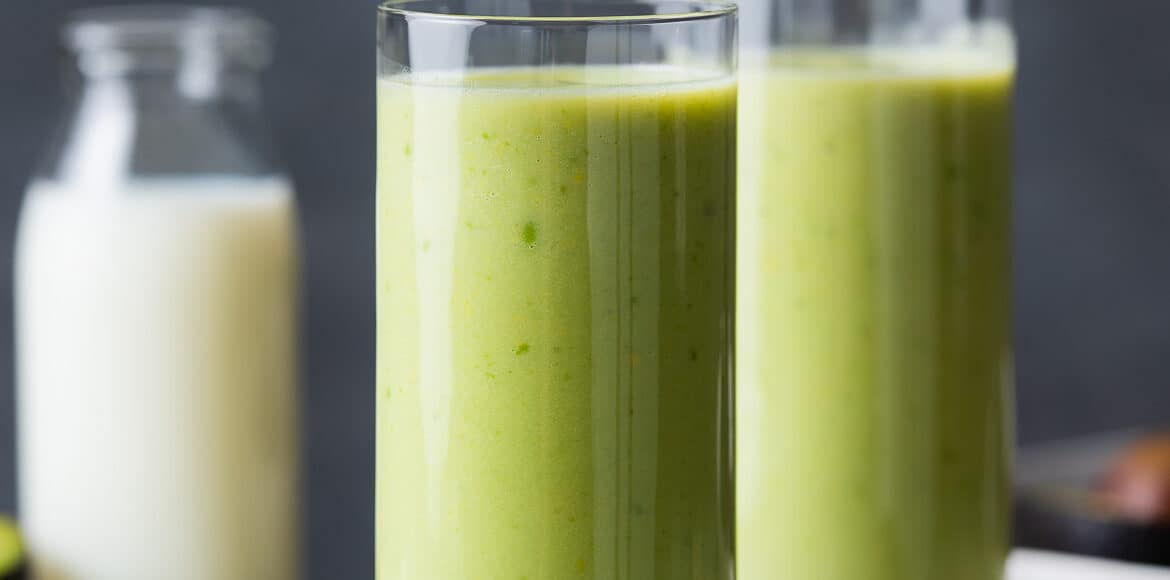 Avocado milk smoothie in two tall glasses.