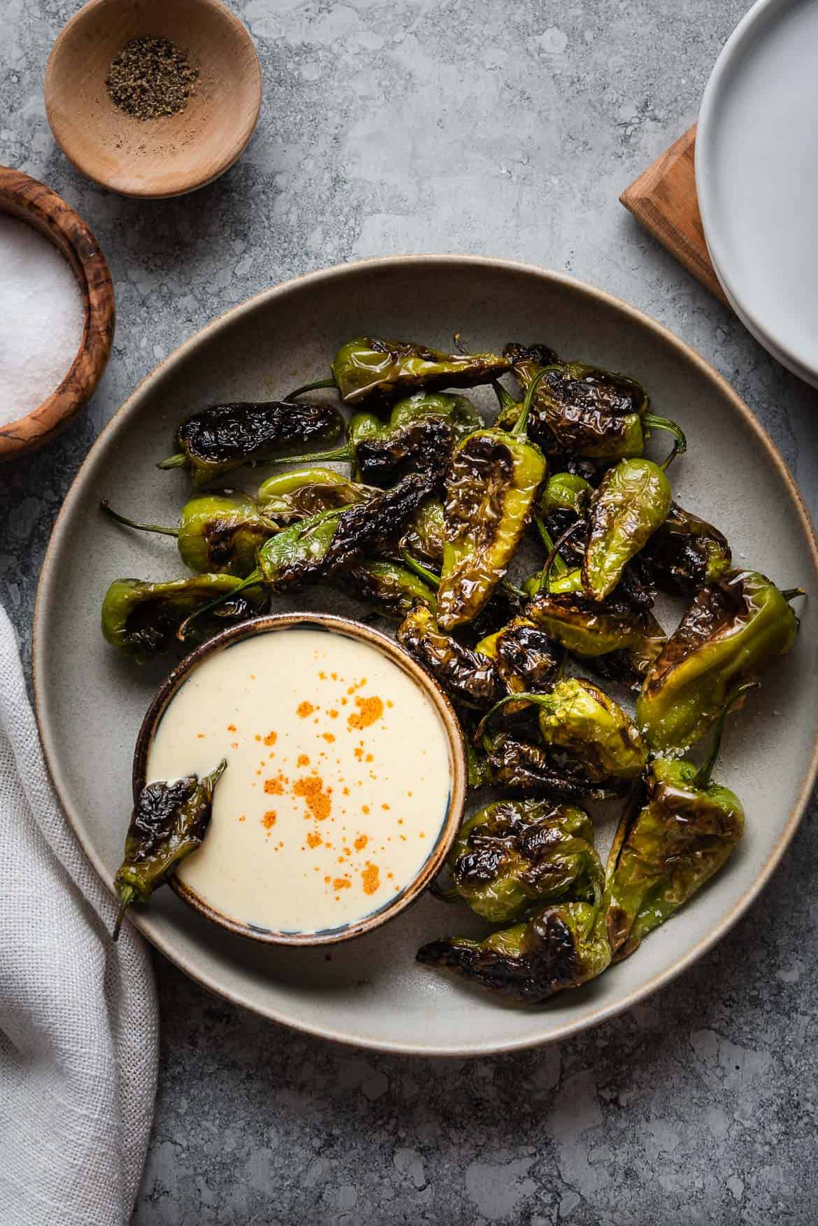 Blistered Padrón Peppers served with a bowl of Buttermilk Aioli.