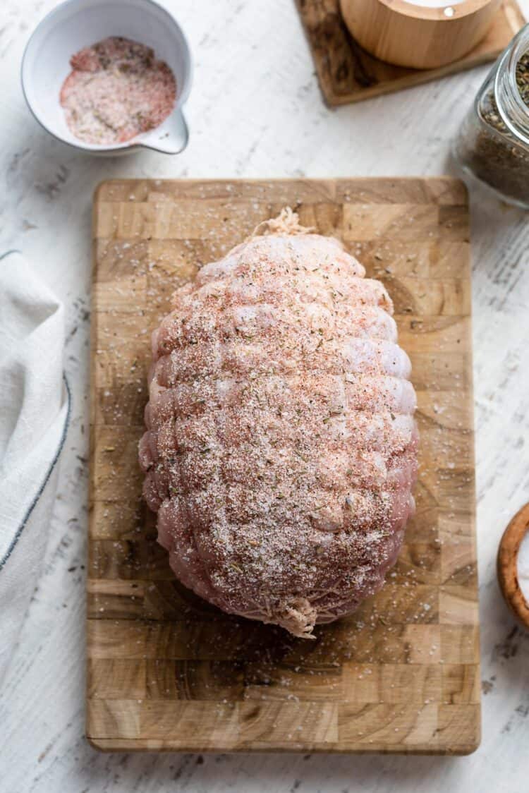 boneless turkey breast on a cutting board with seasoning