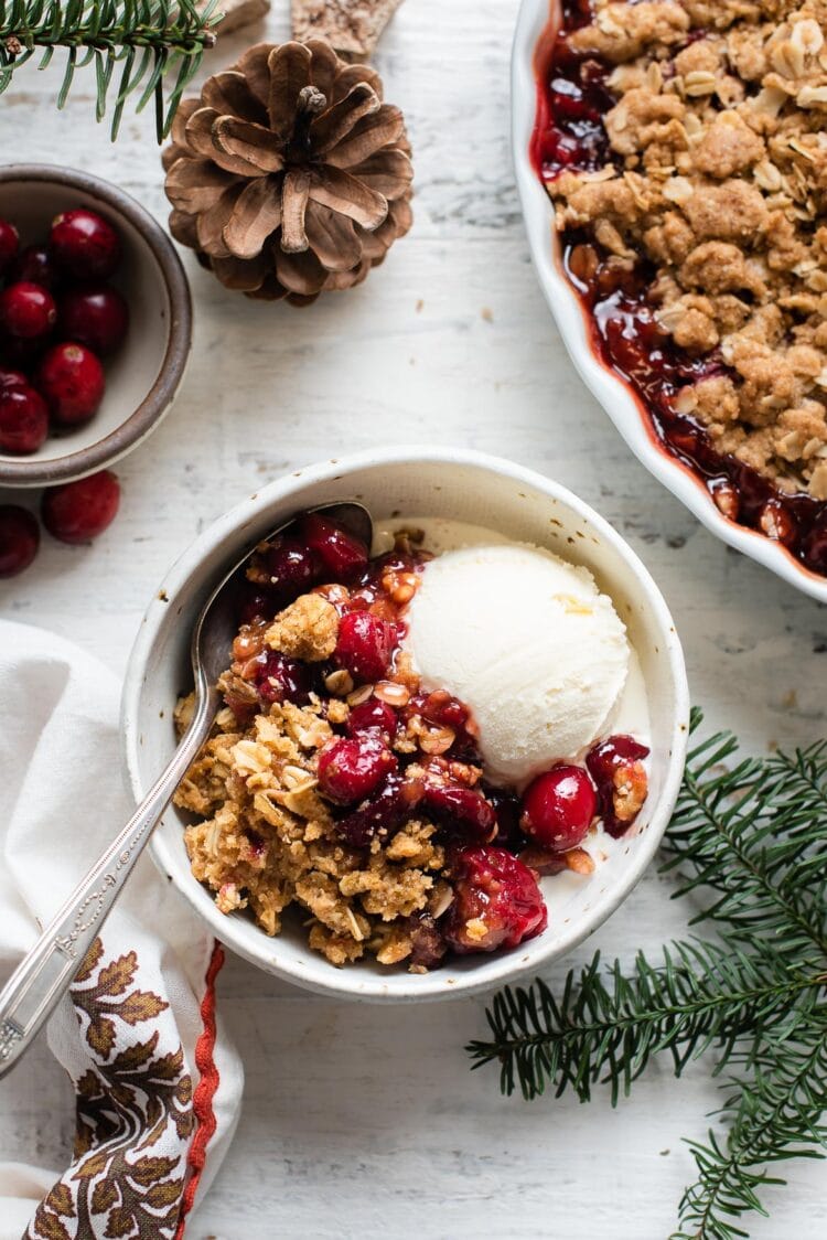 Cranberry Apple Crisp and vanilla cream in a white bowl.