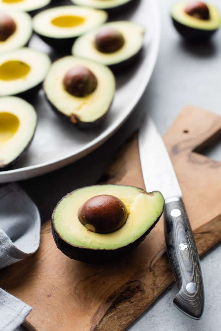 Avocados sliced in half, ready to create Endive Spears with Crab, Pomelo, & Avocado.