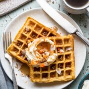 Carrot Cake Waffles with Creamed Cheese Whipped Cream on a plate.