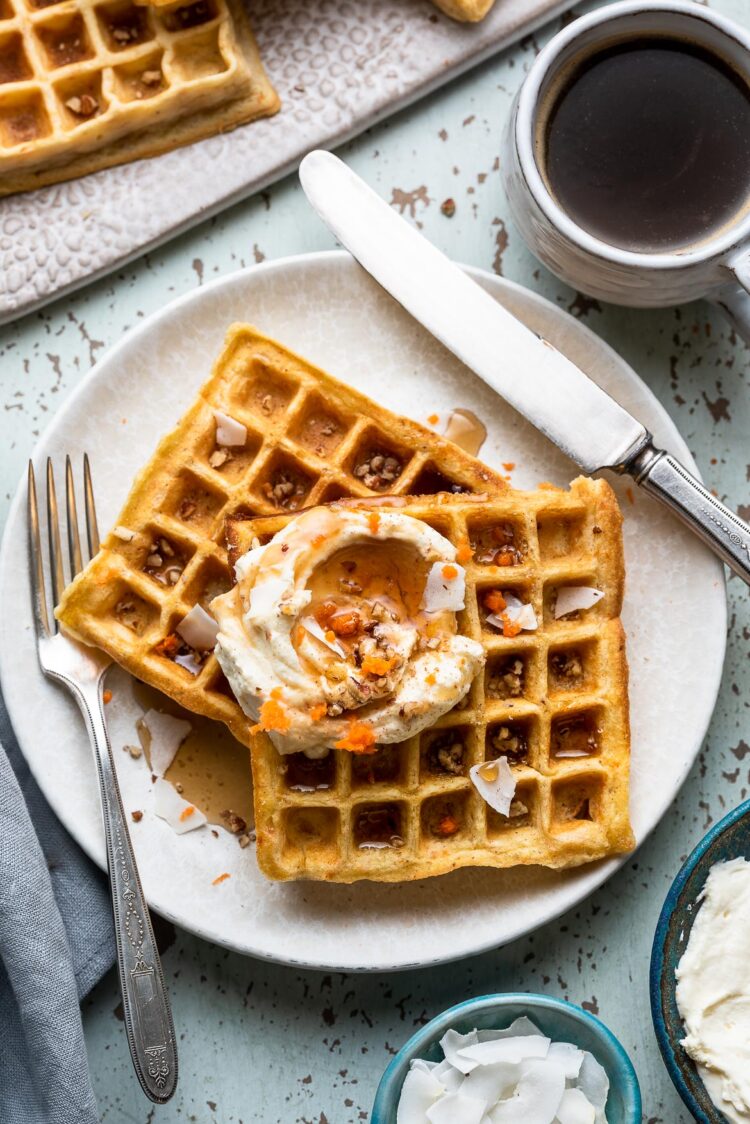 Carrot Cake Waffles with Creamed Cheese Whipped Cream on a plate.
