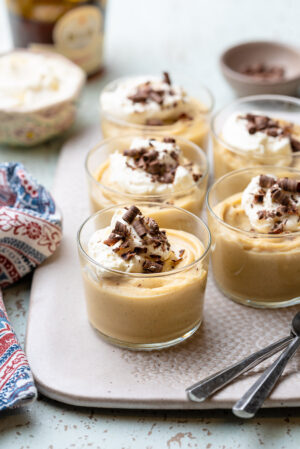 Cognac Butterscotch Pudding in glass cups topped with whipped cream and chocolate shavings.