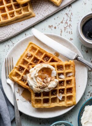 Carrot Cake Waffles with Creamed Cheese Whipped Cream on a plate.