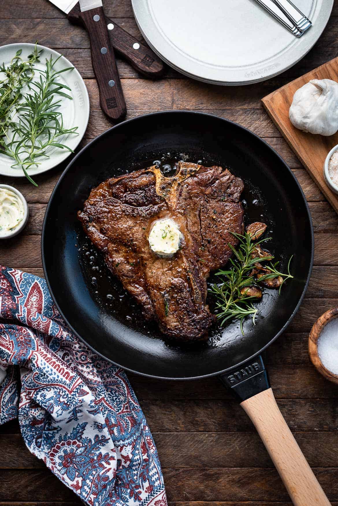 Angus Beef Steak Recipe with Garlic Herb Compound Butter in a cast iron pan by Staub